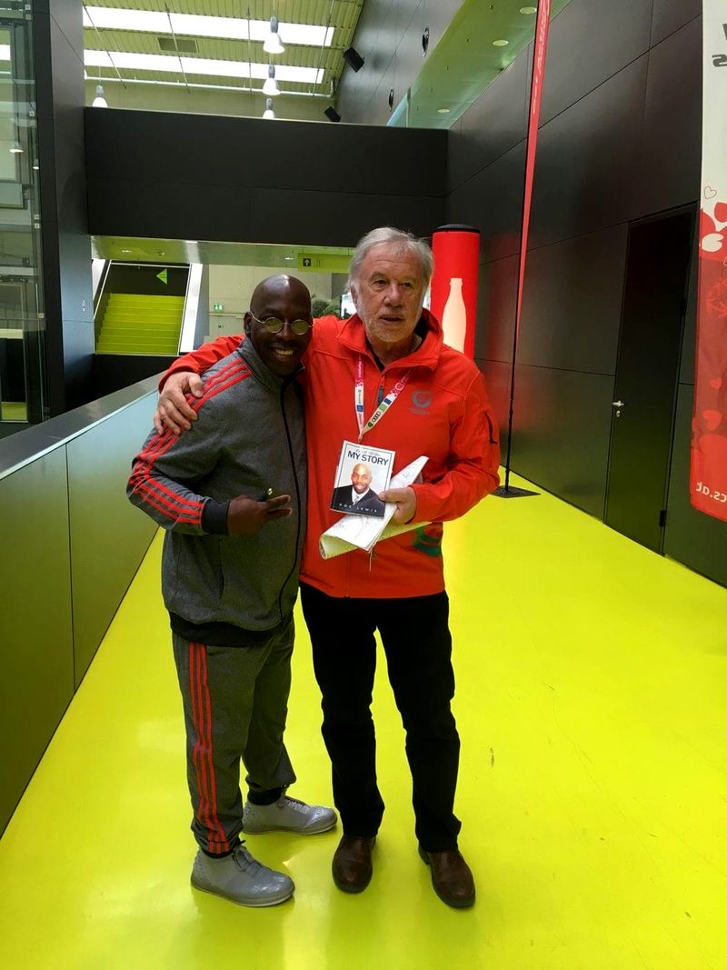 Doc Lewis with a friend holding his book at the Special Olympics World Winter Games in Austria