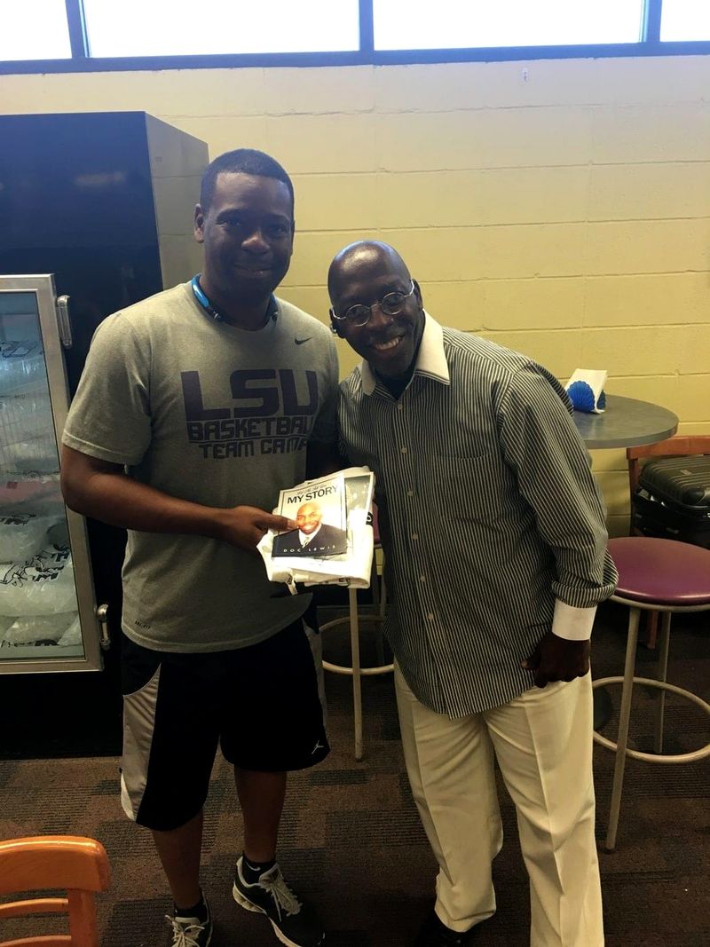 Doc Lewis with a friend who is holding a copy of his book