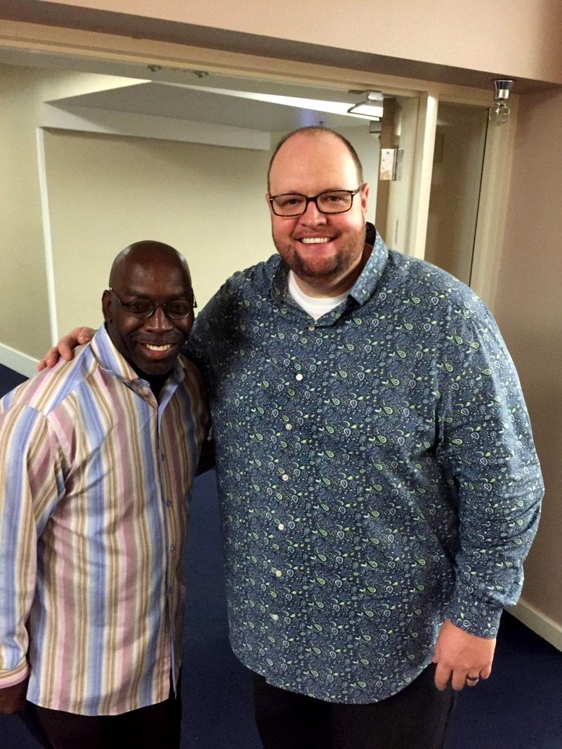 Doc Lewis with a friend in a patterned shirt