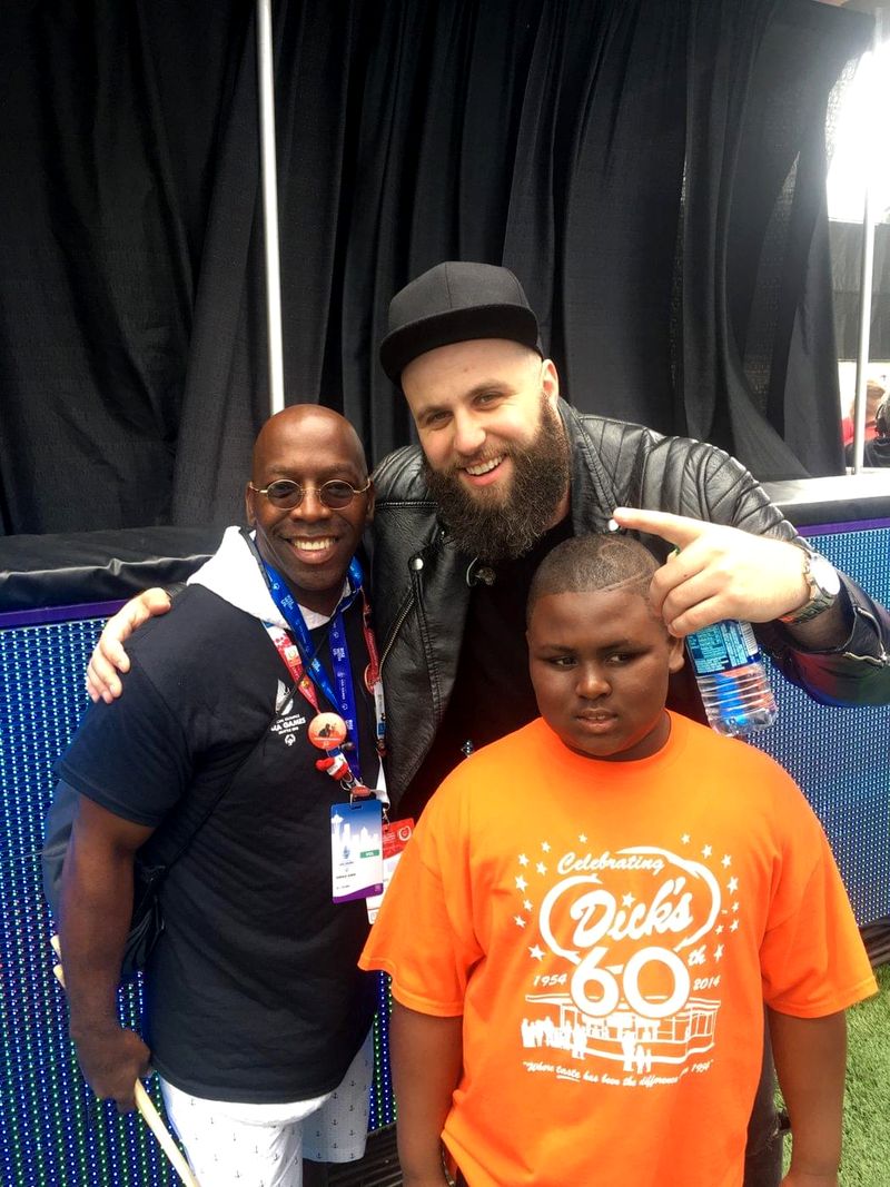 Doc Lewis with a man in a cap and a boy in an orange T-shirt