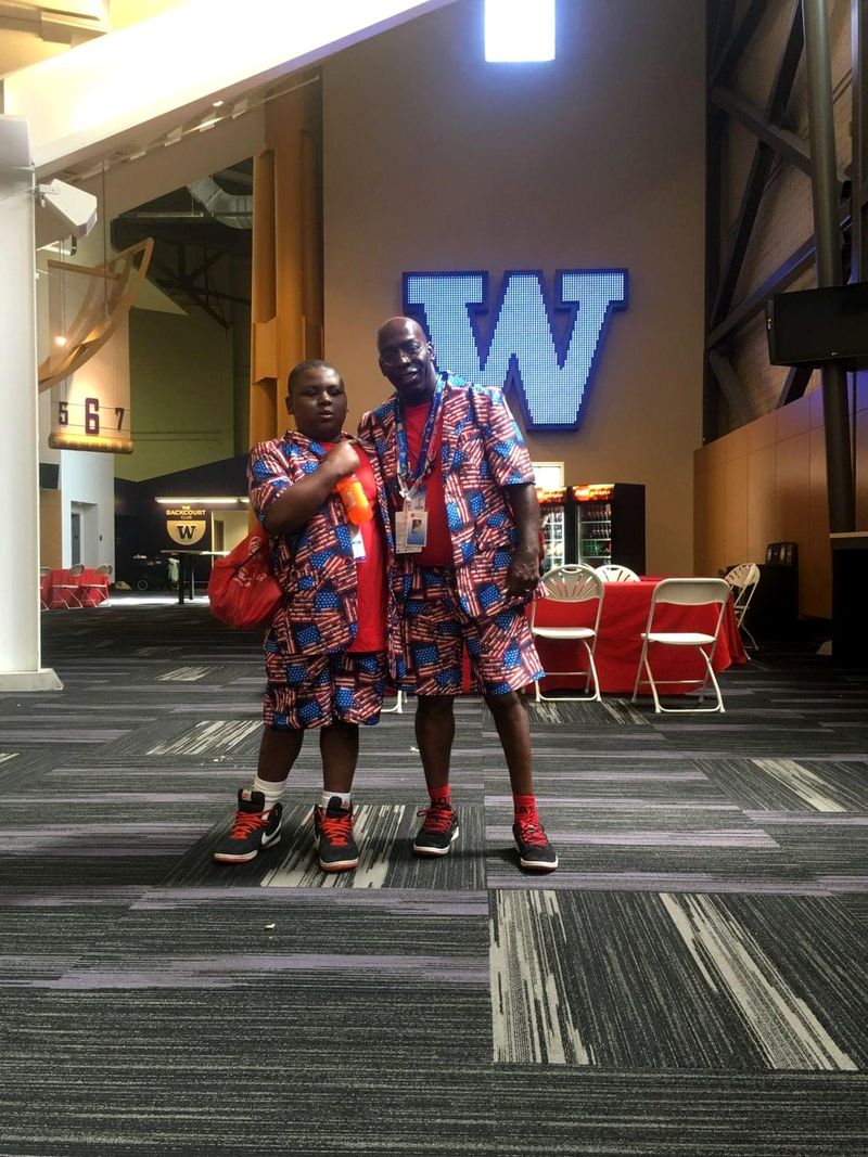 Doc Lewis and a young man in matching patterned outfits beneath a large letter W
